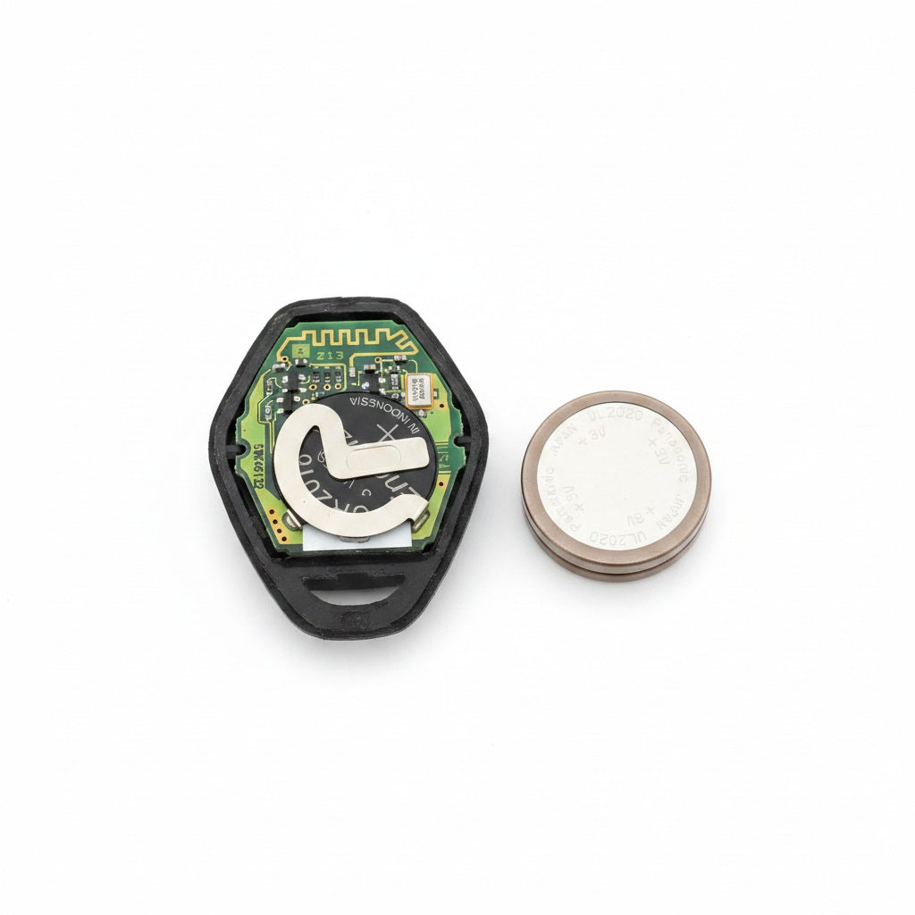 Car key fob repair — opened fob with new battery, professional studio photo